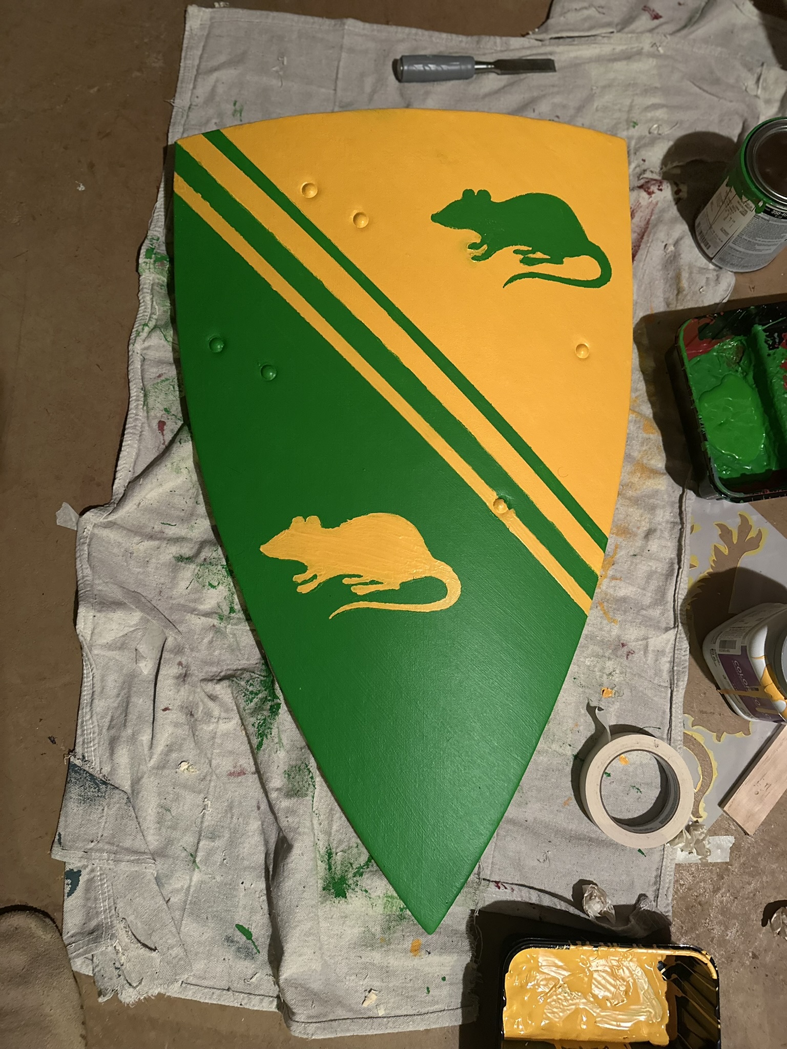 A heater shield painted yellow and green with rats